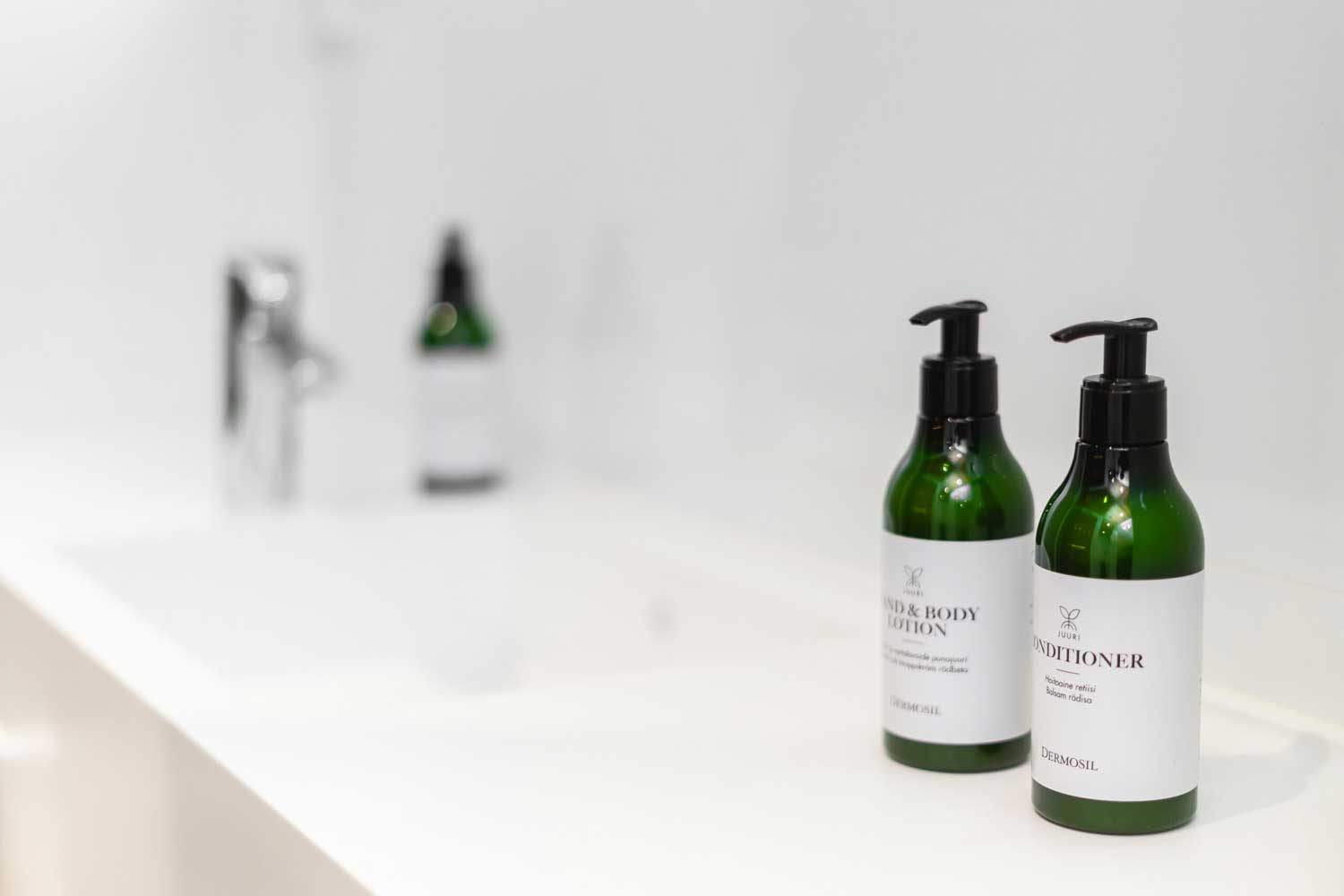 Shampoo- ja hoitoainepullot Hotel Mattsin kylpyhuoneessa.