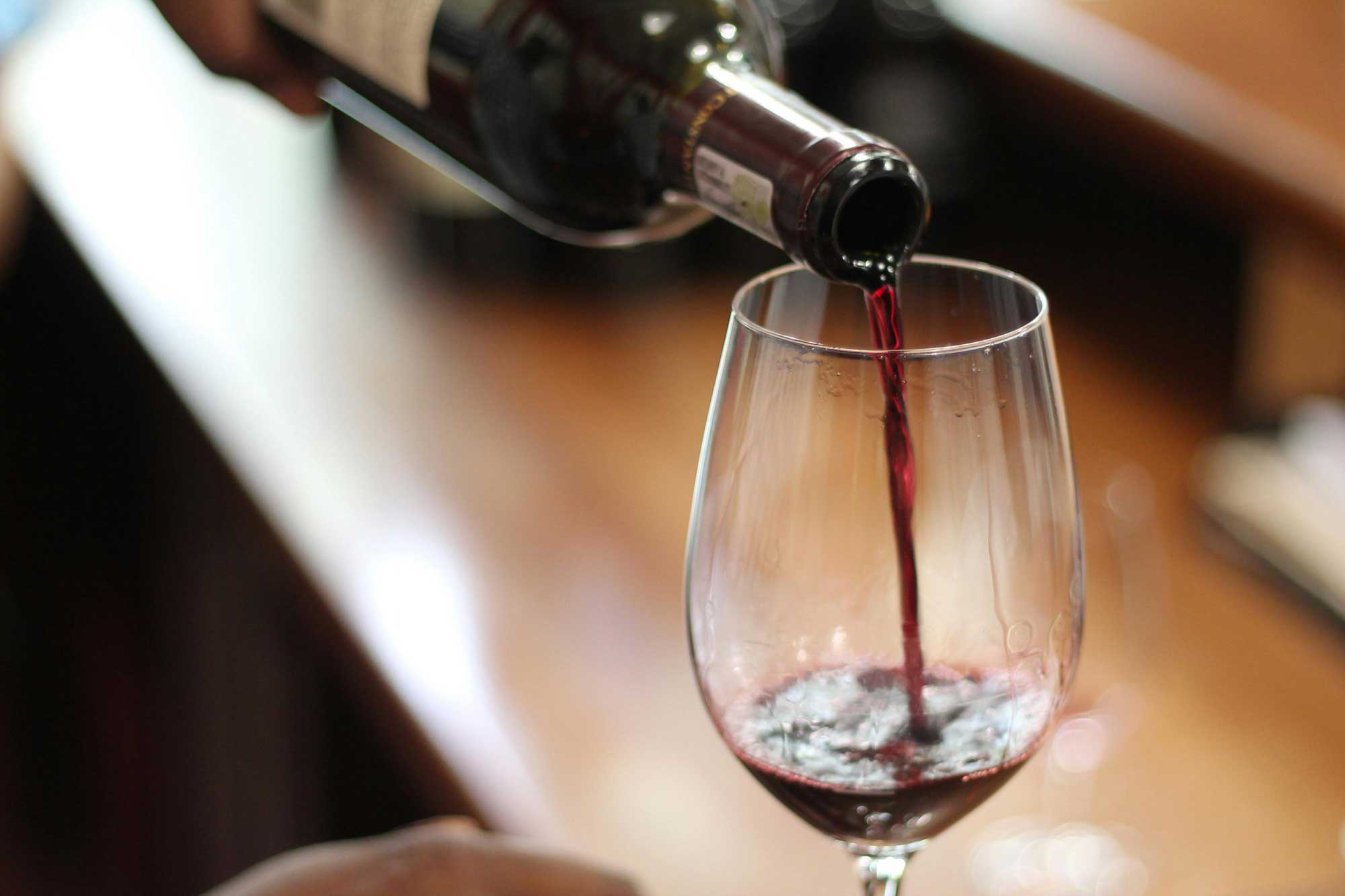 Punaviiniä kaadetaan lasiin.