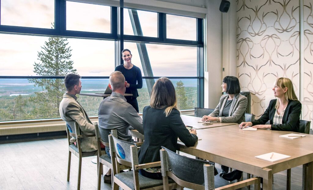 Ihmisiä pitämässä kokousta Levi Summitin maisemakokoustilassa Levillä.
