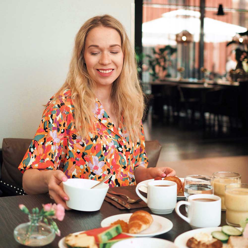 Nainen syömässä Ravintola Frejan aamiaisella.