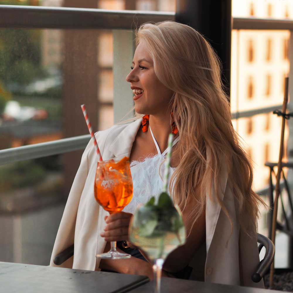 A woman enjoying a drink at Freja Rooftop.