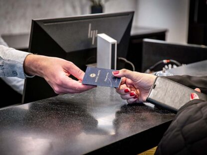 Hotellityöntekijä ojentaa avainkortin asiakkaalle Hotel Mattsissa Espoossa.